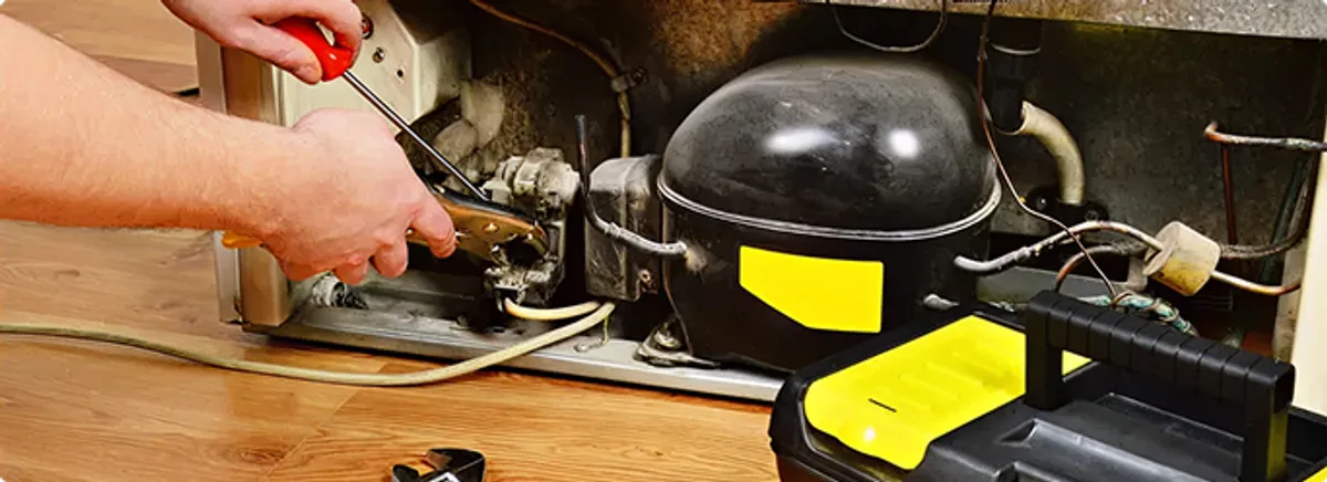 Refrigerator repair technician fixing the compressor and wiring in Seminole, FL