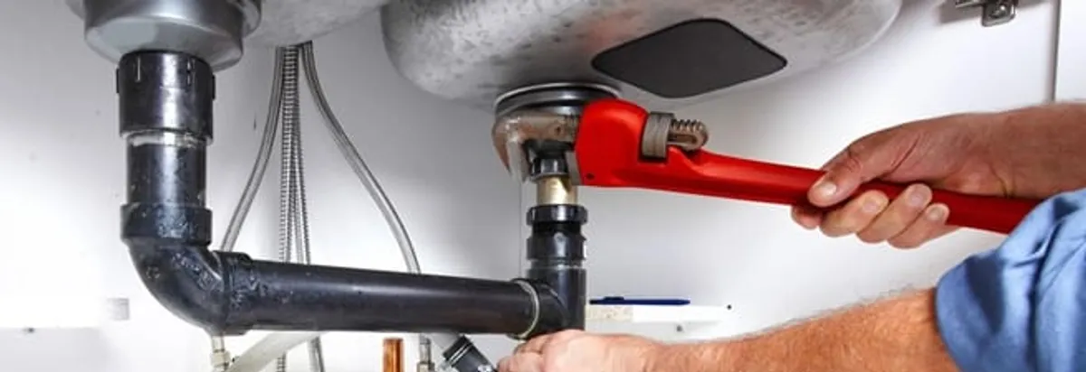 Garbage disposal repair technician tightening the sink drain and disposal connection in Saint Petersburg, FL